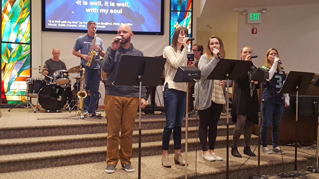 Grace Band leading worship, with vocalists, saxophone, and drums on stage